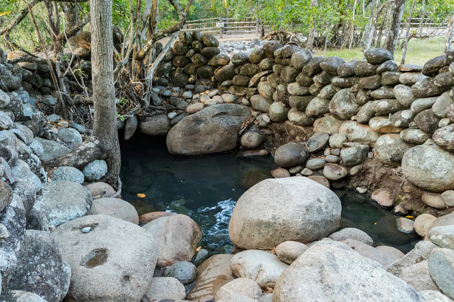 Stone-walled hot spring pool beside the river near Caldera, Boquete