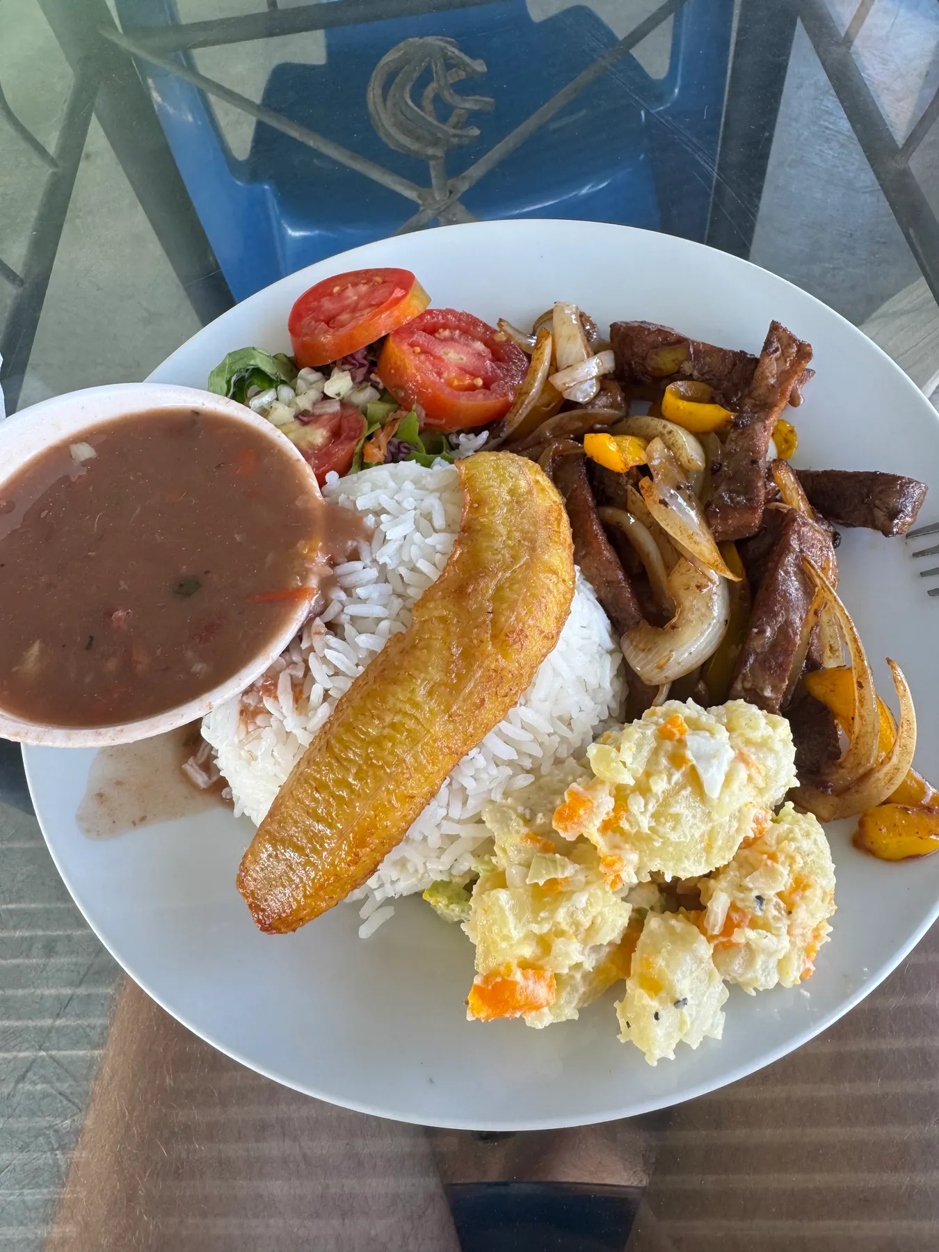 Plate of the day at a local fonda in Boquete: beef with onions and peppers, rice, fried plantain, potato salad and a bowl of bean soup