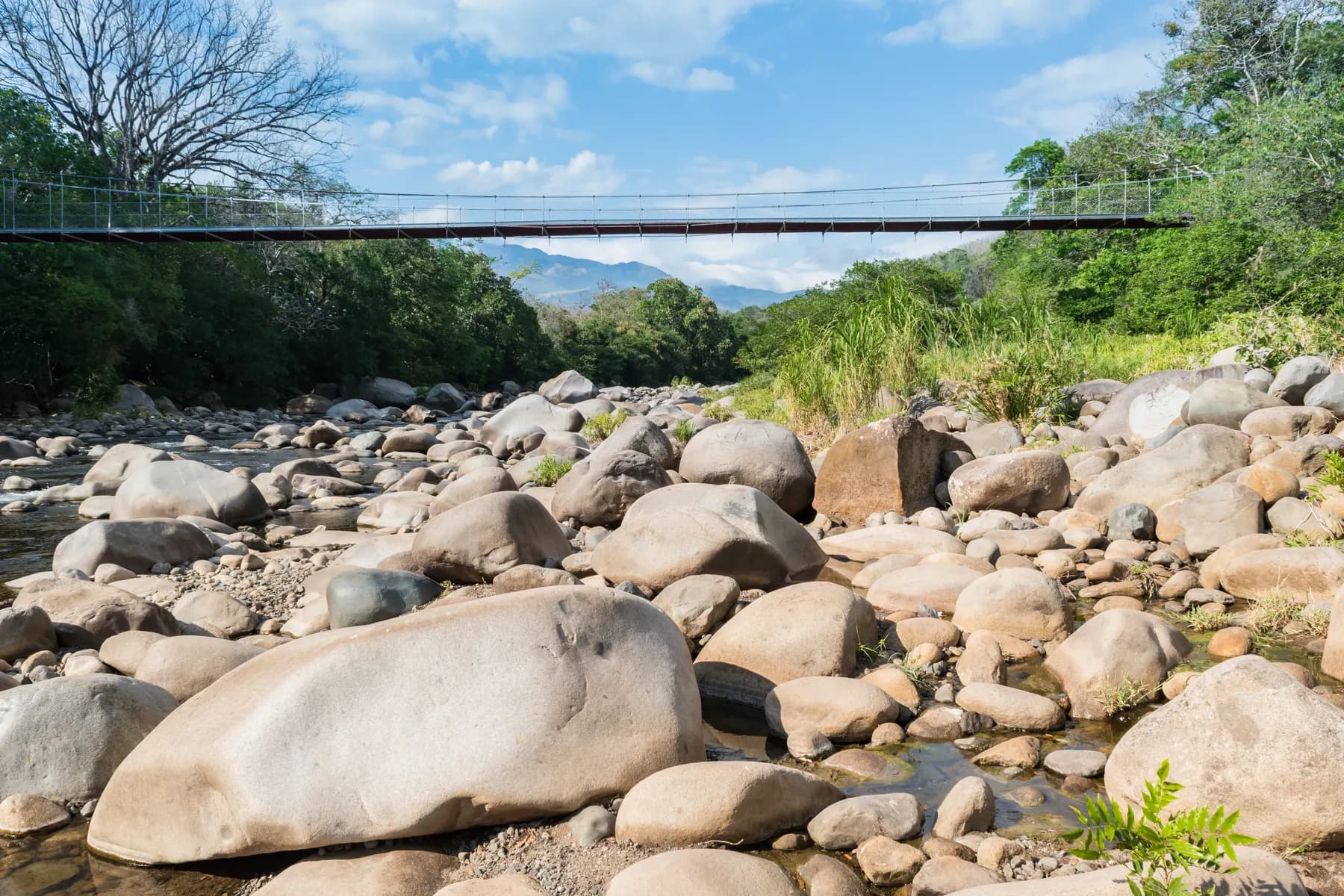 Rocky riverbed and suspension bridge by the Caldera hot springs