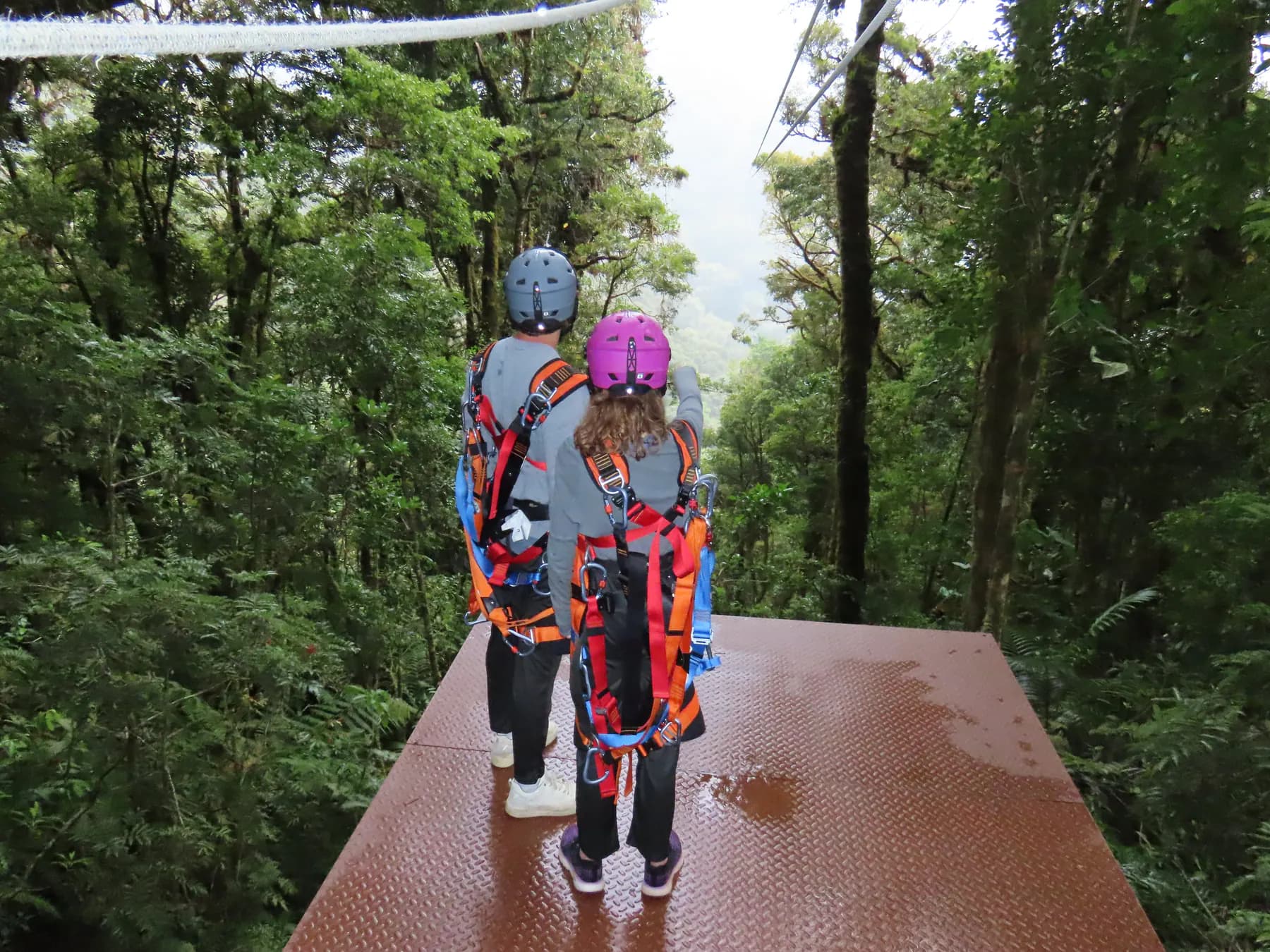 Riders walking out onto the high launch platform of the Superman zipline above the Boquete cloud forest